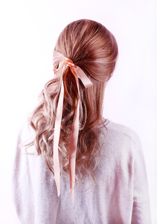Female hairstyle with color ribbon on white wall backgroundの写真素材
