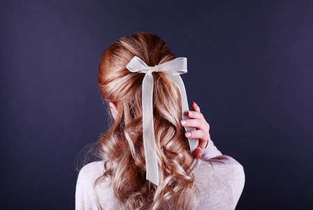 Female hairstyle with color ribbon on dark backgroundの写真素材