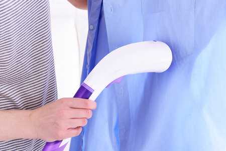 Women steaming shirt in roomの写真素材