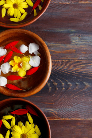 Flower petals in bowls, close-up, on wooden table backgroundの写真素材