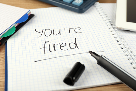 Message You're Fired on notebook on wooden table, closeupの写真素材