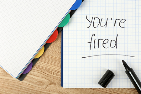 Message You're Fired on notebook on wooden table, closeupの写真素材