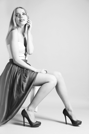 Expressive young model sitting on chair in shades of grayの写真素材