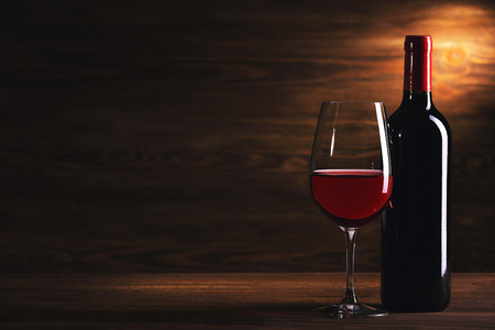 Wineglass and bottle on wooden backgroundの写真素材