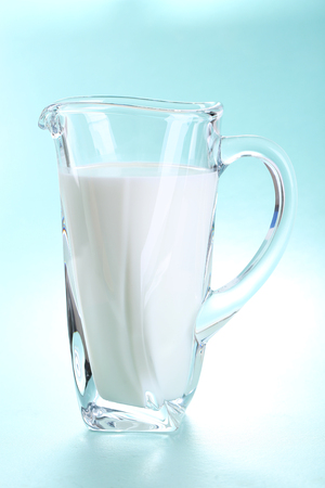 Pitcher of milk on blue backgroundの写真素材