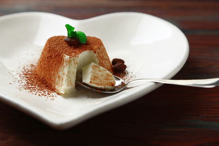 Tasty panna cotta dessert on plate, on wooden tableの写真素材
