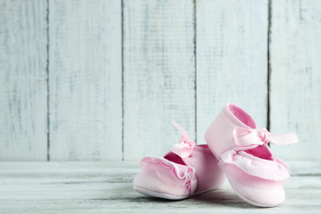 Pink toddler shoes on wooden background