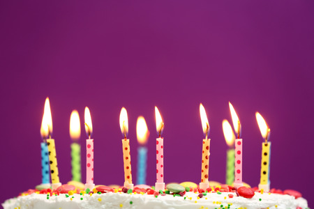 Birthday cake with candles on purple backgroundの写真素材