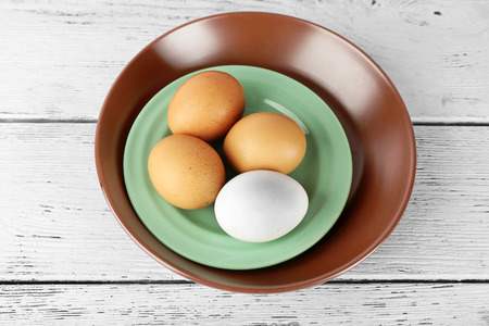 Group of eggs on plate on wooden backgroundの写真素材