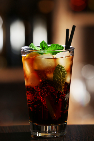 Glass of cocktail in bar on bright blurred backgroundの写真素材