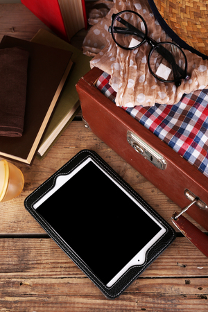 Packing suitcase for trip on wooden backgroundの写真素材