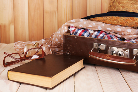 Packing suitcase for trip on wooden backgroundの写真素材