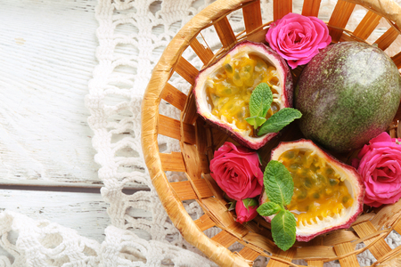 Passion fruits in basket on color wooden backgroundの写真素材