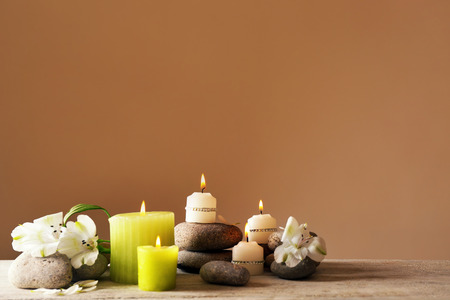 Beautiful composition with candles and spa stones on light backgroundの写真素材