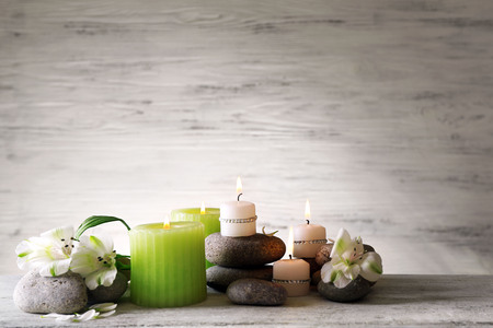 Beautiful composition with candles and spa stones on wooden backgroundの写真素材