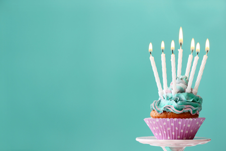 Delicious birthday cupcake on blue backgroundの写真素材