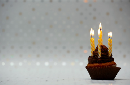 Delicious birthday cupcake on light background