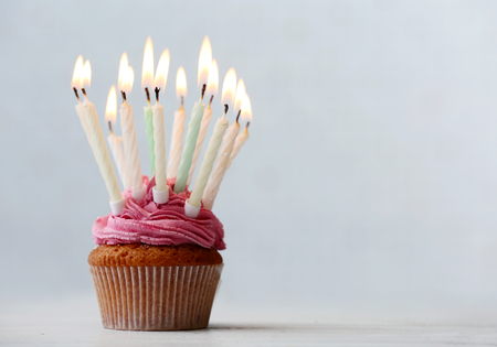 Delicious birthday cupcake on light backgroundの写真素材