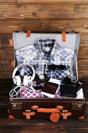 Packed suitcase of vacation items on wooden backgroundの写真素材