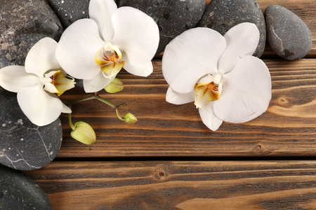 Spa stones and orchid flower on wooden backgroundの写真素材