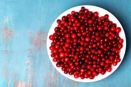 Cranberries in bowl on wooden backgroundの写真素材