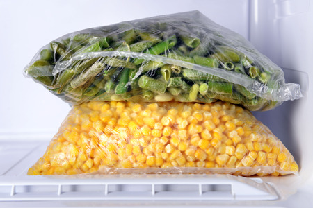 Frozen vegetables in bags in freezer close upの写真素材