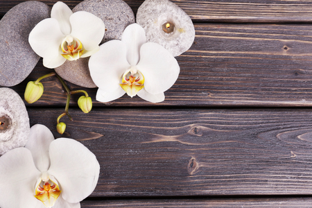 Spa stones and orchid flower on wooden backgroundの写真素材