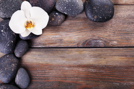 Spa stones and orchid flower on wooden backgroundの写真素材