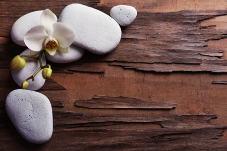 Spa stones and orchid flower on wooden backgroundの写真素材