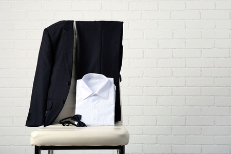 School clothes for boy on chair, on white wall backgroundの写真素材