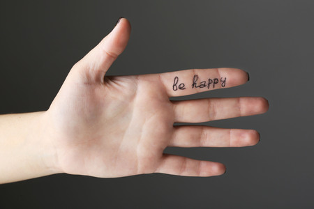 Female hand with written message on gray backgroundの写真素材