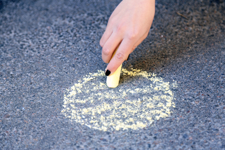 Girl drawing with chalk on asphaltの写真素材