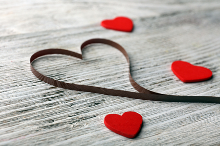 Audio cassette with magnetic tape in shape of heart on wooden backgroundの写真素材