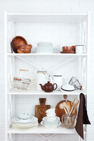Kitchen shelving with dishes on white brick wall backgroundの写真素材