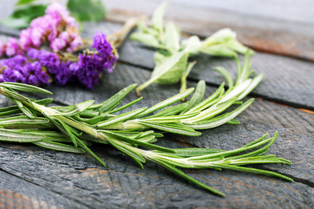 Green herbs and leaves on wooden  table, closeupの写真素材