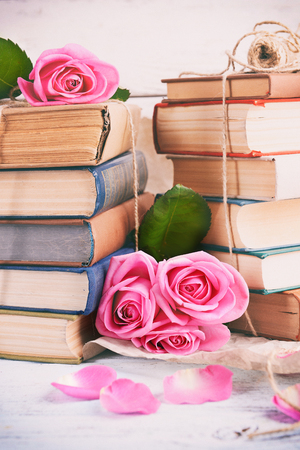 Beautiful pink roses with stack of books, closeupの写真素材