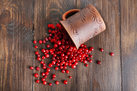 Red cranberries with cup on wooden table, top viewの写真素材