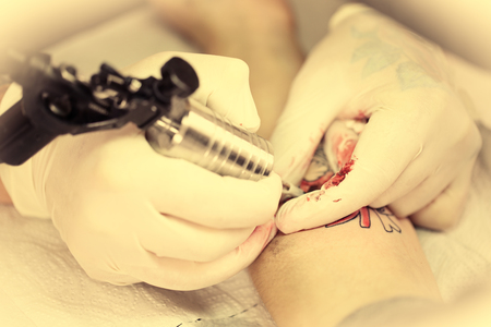 Tattoo artist at work, close-upの写真素材