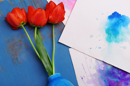 Red tulips in vase on wooden background top viewの写真素材