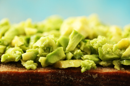 Slice of rye bread with guakomole avocado on color wooden background