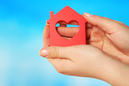Female hands with model of house on color backgroundの写真素材