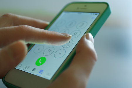Finger touch number on smartphone to make a call, close upの写真素材