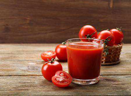 Glass of fresh tomato juice on wooden backgroundの写真素材