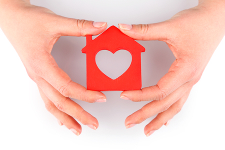 Female hands with model of house isolated on whiteの写真素材