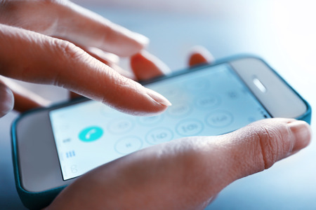 Finger touch number on smartphone to make a call, close upの写真素材