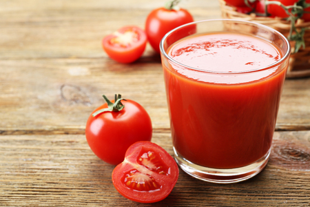 Glass of fresh tomato juice on wooden backgroundの写真素材