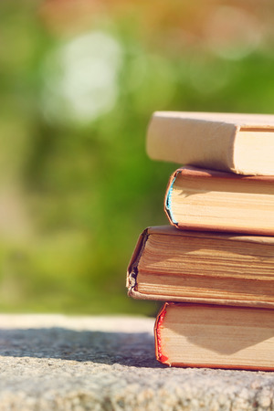 Stack of books outdoors, on blurred backgroundの写真素材