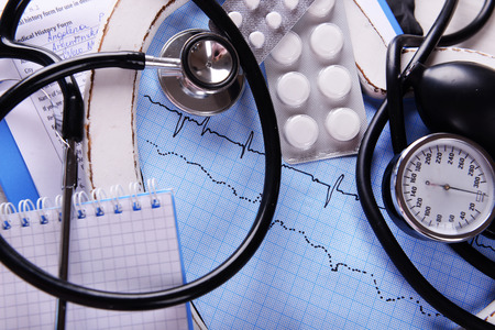 Cardiogram with stethoscope and pills on table, closeupの写真素材