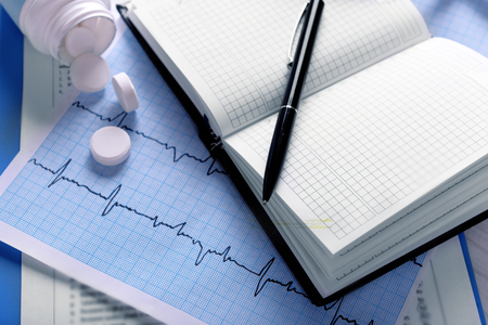 Cardiogram with pills on table, closeupの写真素材