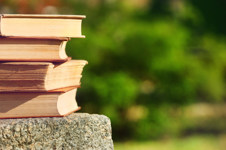 Stack of books outdoors, on blurred backgroundの写真素材